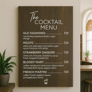 Könnte beinhalten: Eine Cocktailkarte aus dunklem Holz mit weißer Schrift. Die Karte listet klassische Cocktails wie Old Fashioned, Mojito, Strawberry Daiquiri, Bloody Mary und French Martini auf. Die Karte wird in einer Bar angezeigt.