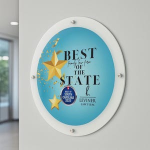 Op de afbeelding: Een ronde, heldere acrylbord met een witte rand. Het bord toont de woorden "BEST OF THE STATE" in zwart en een gouden ster-afbeelding. De tekst "BEST OF SOUTH CAROLINA 2025" is ook zichtbaar.