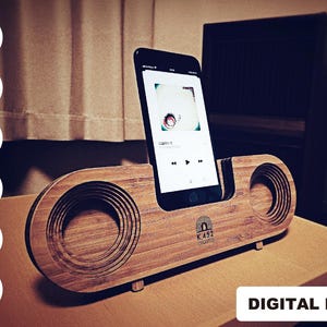 May include: A wooden phone stand with a speaker on the side. The stand is designed to hold a smartphone vertically. The phone is displaying a music player app with the text "K.452" on the screen.