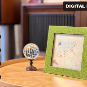 May include: A green picture frame with a textured surface sits on a wooden table. The frame contains a drawing of a scene with people and animals. The text "DIGITAL FILE" is in the upper right corner of the image.