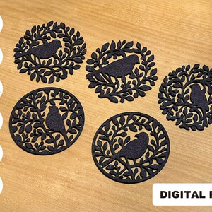 May include: Five black, circular cutouts featuring bird silhouettes within leafy branch designs. The cutouts are arranged on a light brown wooden surface. The text "DIGITAL FILE" is visible in the lower right corner.
