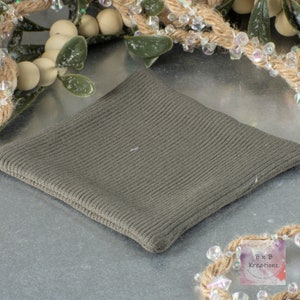 May include: A gray ribbed fabric swatch. The fabric is soft and has a subtle texture.