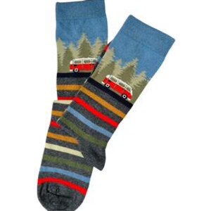 May include: A pair of crew socks featuring a blue upper section with a forest landscape and a red camper van graphic. The lower portion of the socks displays horizontal stripes in shades of grey, blue, yellow, and red, ending in a dark grey toe.