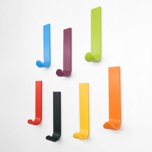 Peut inclure: Ensemble de trois mugs en céramique avec une finition mate et mouchetée. Les tasses sont de couleur crème, gris clair et gris foncé. Chaque mug a un design simple et minimaliste.