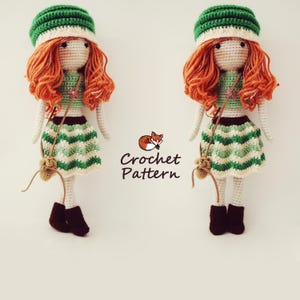 May include: Two crocheted dolls with green and white striped skirts, green hats, and long orange hair. The dolls are holding brown bags and are standing on a white background. The text "Crochet Pattern" is written below the dolls.