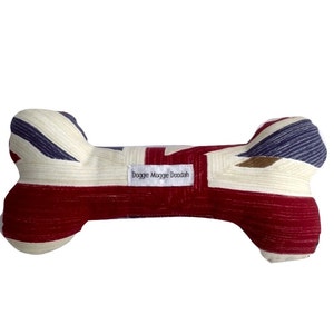 May include: A red, white and blue dog bone toy with a Union Jack pattern. The bone has a white label that says "Doggie Moggie Doodah".