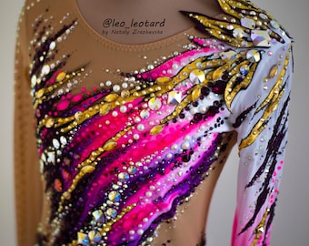May include: A long-sleeved leotard with a colorful abstract design featuring pink, purple, white, and gold accents. The leotard is embellished with rhinestones and pearls. The text "@leo_leotard by Nataly  Zrazhevksa" is visible on the leotard.