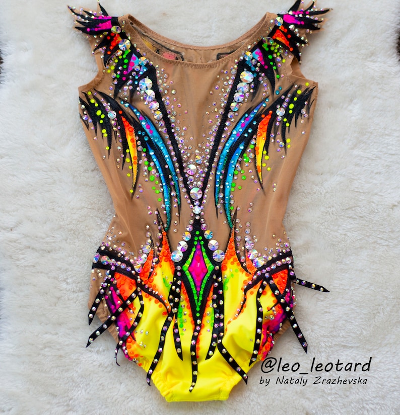 Pu&ograve; includere: Un body giallo, nero e arcobaleno con strass. Il body &egrave; senza maniche e ha un'alta scollatura. Il body &egrave; decorato con un motivo a fiamma colorato. Il body &egrave; realizzato in un tessuto trasparente. Il body &egrave; adatto per ginnastica o danza. @leo_leotard by Nataly  Zrazhevksa
