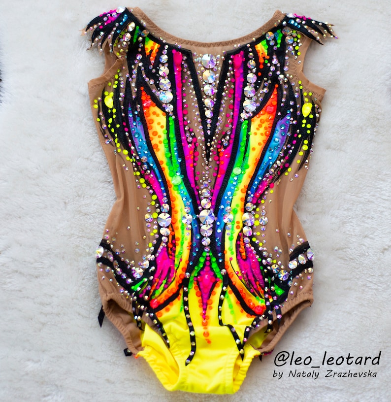 Pu&ograve; includere: Un body colorato con un design arcobaleno e accenti neri. Il body &egrave; realizzato in un tessuto trasparente con strass ed &egrave; decorato con un bordo giallo. Il body &egrave; progettato per la ginnastica o la danza. @leo_leotard by Nataly  Zrazhevksa