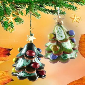 Op de afbeelding: Twee kerstboomversieringen van keramiek, een groene met witte en gouden accenten en de andere bruin met groene en rode accenten. Beide versieringen hebben een ster bovenop en zijn versierd met gekleurde kralen.