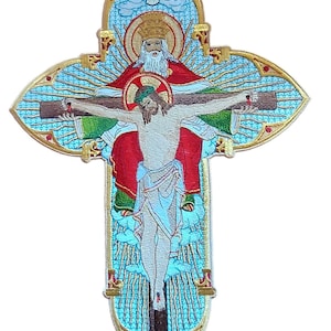 May include: Embroidered religious cross featuring Jesus on the cross, with God and the Holy Spirit above. The cross has a blue, gold, red, and green color scheme. The design is detailed and ornate, with a stained-glass effect.