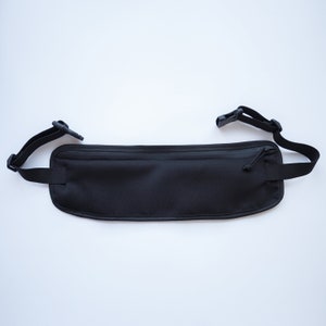 May include: Black travel money belt with a zippered pocket and adjustable straps.