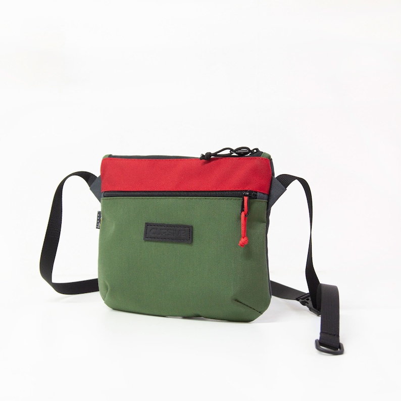 May include: A green and red crossbody bag with a black zipper and a black label that says "CHROME" on it.