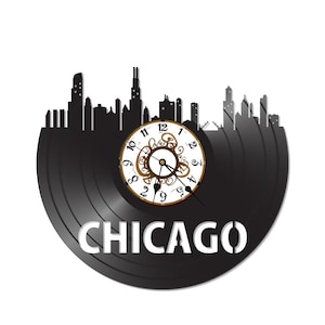 May include: Black vinyl record clock with a white clock face and gold accents. The clock features a silhouette of the Chicago skyline and the word "CHICAGO" in white letters.