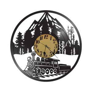 May include: Black wall clock with a train, mountain, and forest silhouette design. The clock face is tan with black numbers and hands. The clock is round and appears to be made from a repurposed vinyl record.