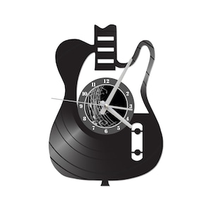 May include: Black vinyl record clock shaped like an electric guitar with white numbers and hands. The clock face has a black and white image of musical notes.