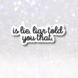 Könnte beinhalten: Ein weißer Aufkleber mit schwarzem Rand und dem Satz "is lie. liar told you that." in einer handschriftlichen Schriftart. Der Aufkleber befindet sich vor einem glitzernden, hellen Hintergrund.