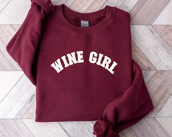 May include: Burgundy sweatshirt with white text that reads "Wine Girl" in an arched font.