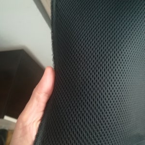 May include: Black mesh fabric with a fine, even weave. The fabric is flexible and has a slight sheen.