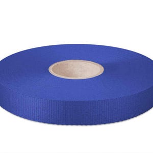 May include: A roll of 20 mm wide blue ribbon. The ribbon is wound around a cardboard core.