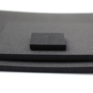 Puede incluir: Tres l&aacute;minas de espuma negra de diferentes tama&ntilde;os apiladas una encima de la otra. La l&aacute;mina superior es cuadrada.