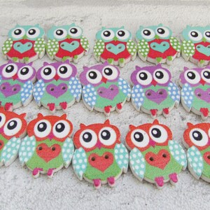 May include: A set of 18 wooden owl buttons with colorful polka dot and heart patterns. The owls have big eyes and are painted in shades of green, blue, purple, red, and white.