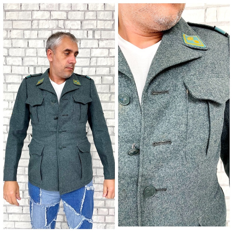 May include: A dark green wool jacket with a button-up front and two flap pockets. The jacket has a collar with a green and yellow patch on the left side.