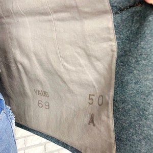 May include: A close-up of a gray fabric with the text "VALID 69" and "50 A" printed on it.
