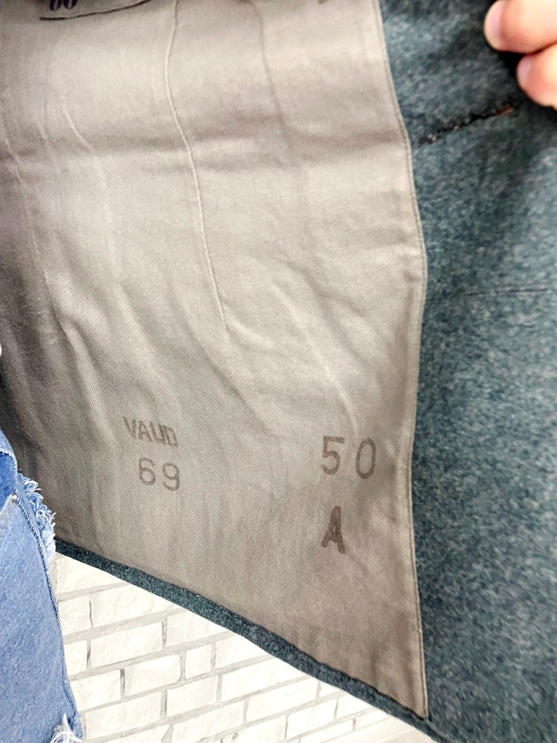 May include: A close-up of a gray fabric with the text "VALID 69" and "50 A" printed on it.
