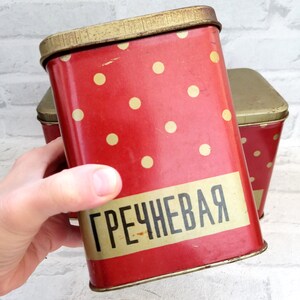 May include: Red metal storage container with white polka dots and the word "ГРЕЧНЕВАЯ" in gold lettering.