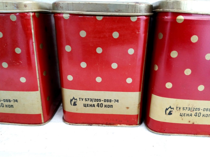 May include: Three red metal canisters with white polka dots and gold trim. Each canister has a label with the text "TY 573/205-088-74 ЦЕНА 40 КОП".