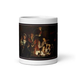 Könnte beinhalten: Weiße Keramik-Kaffeetasse mit einem Detail aus einem klassischen Gemälde. Das Kunstwerk zeigt eine düstere Szene mit mehreren Figuren, die sich um einen Tisch versammeln, der von einer zentralen Lichtquelle beleuchtet wird. Die Tasse hat einen schwarzen Rand.