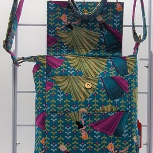 Peut inclure: Un sac &agrave; bandouli&egrave;re bleu sarcelle avec une fermeture &agrave; rabat. Le sac est d&eacute;cor&eacute; d'un motif r&eacute;p&eacute;t&eacute; de feuilles vertes et d'images des personnages du film La Reine des Neiges. Le sac a une fermeture &agrave; bouton dor&eacute;e et une longue bandouli&egrave;re r&eacute;glable.