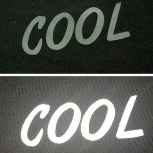 May include: Close-up of two fabric swatches with the word "COOL" printed in white on a black background. The top swatch has a matte finish, while the bottom swatch has a reflective finish.