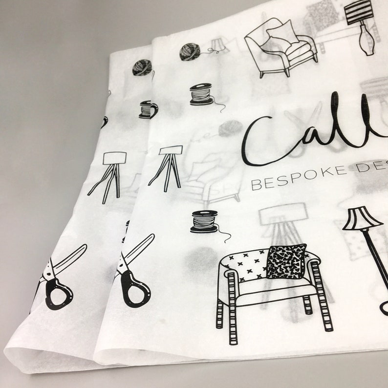 K&ouml;nnte beinhalten: Wei&szlig;es Seidenpapier mit einem schwarzen Muster aus M&ouml;beln und N&auml;hutensilien, mit den Worten "Call Bespoke Design". Das Design umfasst St&uuml;hle, Lampen, Scheren und Garnrollen. Das Papier ist gefaltet.
