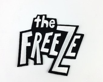 May include: White embroidered patch with the text "the FREEZE" on a black background.