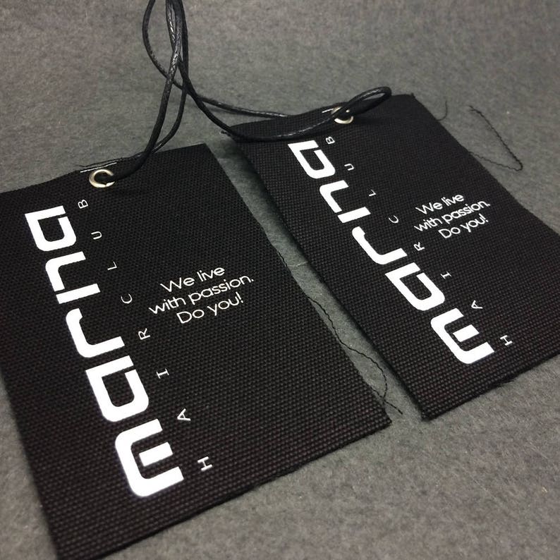 May include: Two black fabric tags with white text that reads "marina club" and "We live with passion. Do you!"