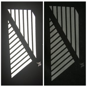 May include: Two images of a reflective, white, geometric pattern on a black background. The pattern is made up of diagonal lines and stripes.