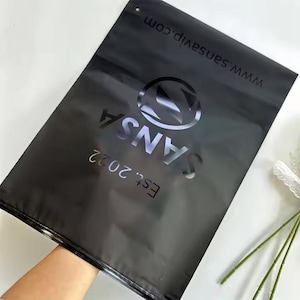 100 UVロゴカスタムジッパーTシャツバッグ、ロゴ付きUVプリント、リサイクル可能なプラスチックプライムブランドパッキング、つや消しブラックジッパー、衣類バッグ