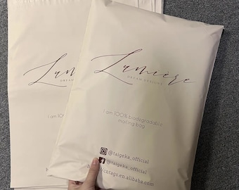 May include: Cream-coloured mailing bags with the "Lumiere Dream Designs" logo in a cursive font. The bags have the text "I am 100% biodegradable mailing bag" and social media handles. The bags are stacked on top of each other.