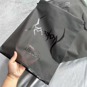 Sacchetti di imballaggio con cerniera sigillati opachi neri personalizzati per magliette/felpe con cappuccio/pantaloni con buste di plastica con logo