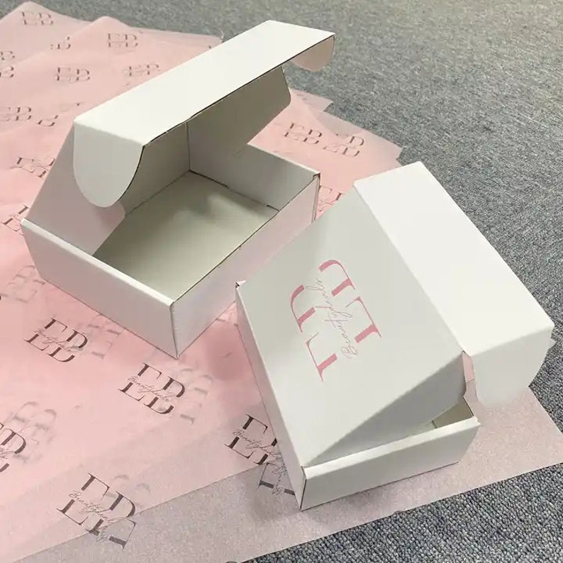 May include: Two white cardboard boxes with the text "you're beautiful" printed in pink on one of the boxes. The boxes are open and are sitting on a pink tissue paper background.
