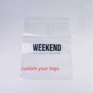 Może przedstawiać: Przezroczysta plastikowa torba z czarno-białym logo z napisem "Weekend Active" i tekstem "custom your logo" w kolorze czerwonym.