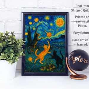 Op de afbeelding: Een ingelijste print met een grillige sc&egrave;ne van katten die met garen spelen onder een sterrenhemel, in de stijl van Van Gogh. Het kunstwerk bevat levendige blauwe, gele en oranje tinten. Een wereldbol met het woord "Explore" is ook zichtbaar.