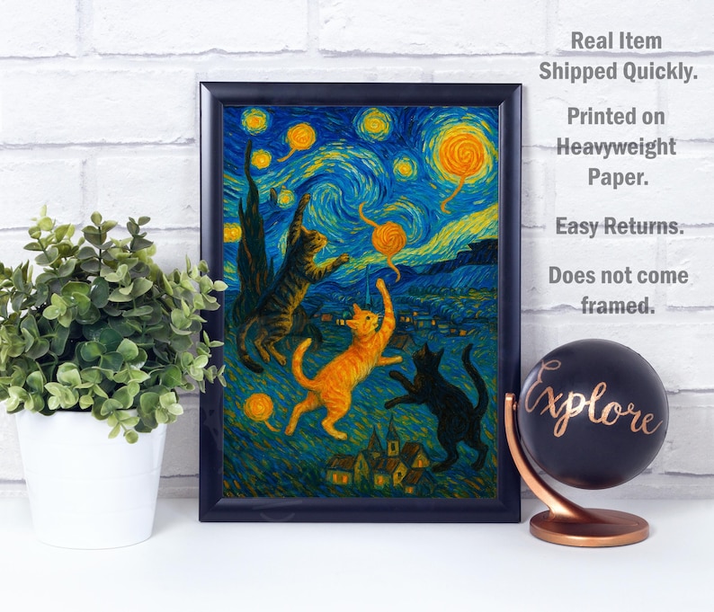 Op de afbeelding: Een ingelijste print met een grillige sc&egrave;ne van katten die met garen spelen onder een sterrenhemel, in de stijl van Van Gogh. Het kunstwerk bevat levendige blauwe, gele en oranje tinten. Een wereldbol met het woord "Explore" is ook zichtbaar.