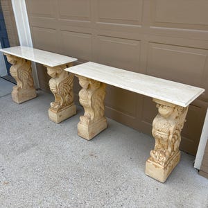 Pair of Neoclassical Travertine Console Tables, Winged Mythological Figure Bases, Hollywood Regency Stone Consoles, Italian Entry Tables