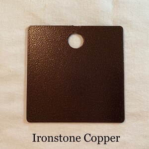 K&ouml;nnte beinhalten: Eine quadratische Probe von Ironstone Copper Farbe. Die Farbe hat eine strukturierte, metallische Oberfl&auml;che.