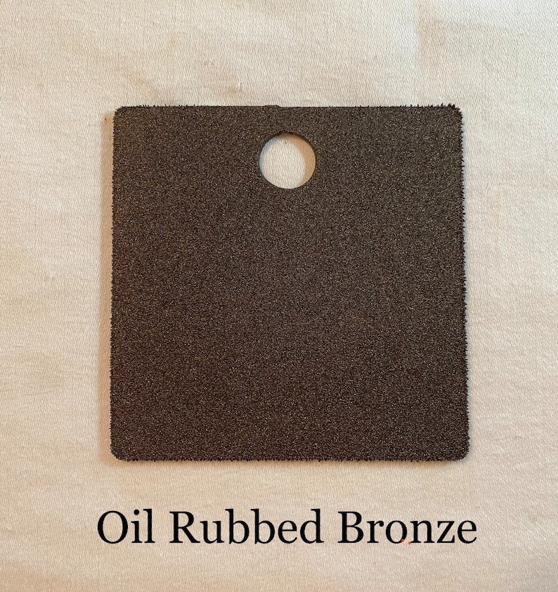 K&ouml;nnte beinhalten: Ein quadratisches Muster in &Ouml;l-Bronze-Finish. Das Muster hat ein Loch in der Mitte.