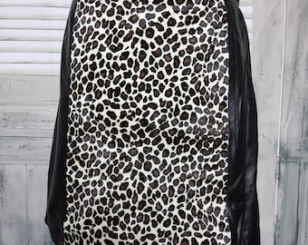 May include: A black and white leopard print skirt with a black leather panel on the sides. The skirt is made of a soft, supple leather and has a classic A-line silhouette.