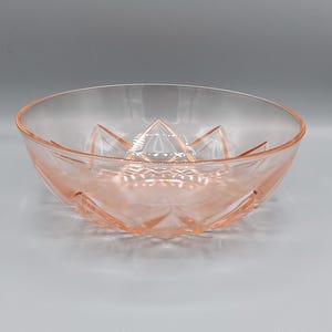 Op de afbeelding: Een roze glazen kom met een diamantpatroon. De kom is helder en heeft een delicate roze tint.